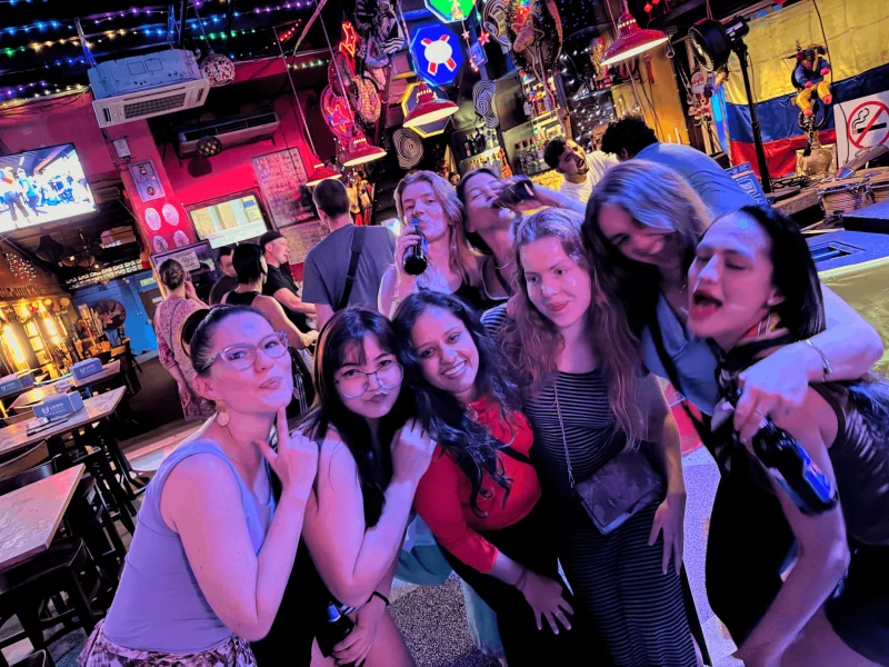 Travelogue Guesthouse guests together at a neon-lit bar in Bukit Bintang, Kuala Lumpur, at night